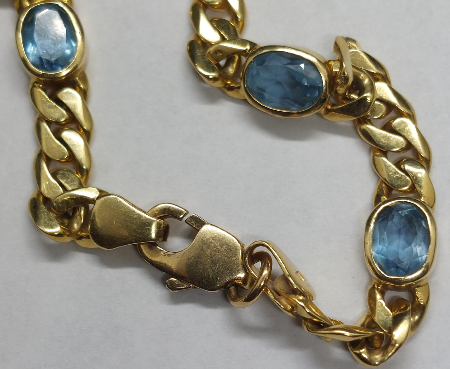 Vintage 18 karat guldarmbånd monteret med facetslebne blå topas